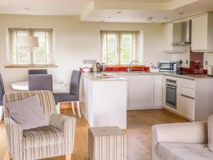 cocina y sala de estar con 2 sillas y mesa en Cottam Cottage Farm en Longridge