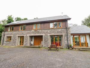 a stone house with a picnic table in front of it at Woodland Villa in Oban