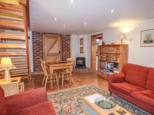 a living room with a couch and a table at Top Stable Cottage in Ireton Wood