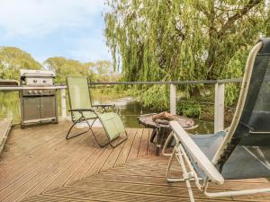 a deck with chairs and a stove and a grill at Island Yurt in Beckford