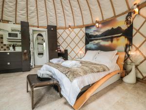 a bedroom with a large bed in a yurt at Island Yurt in Beckford