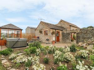 a stone house with a garden in front of it at The Cow Shed in Stanton in Peak