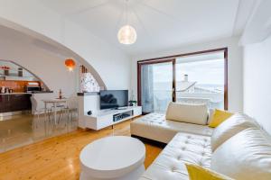 sala de estar con sofá blanco y TV en Apartments Flor de Lis en Podstrana