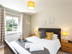 a bedroom with a large bed and a window at 1 Springwater View in Mickleton