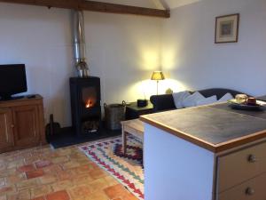 a living room with a fireplace and a stove at Starvegoose Cottage in Goudhurst