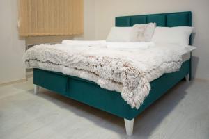 ein grünes Bett mit einer weißen Decke drauf in der Unterkunft Cvetni trg in Belgrad