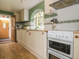 Darshamにある28 Stone Cottageの緑の壁、白い家電製品付きのキッチン