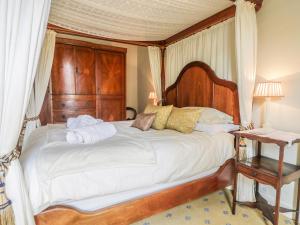a bedroom with a large bed with a wooden canopy at Manor Farm in Hutton Bushel