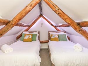 two twin beds in a room with wooden beams at Hoodgill Barn in Newbiggin