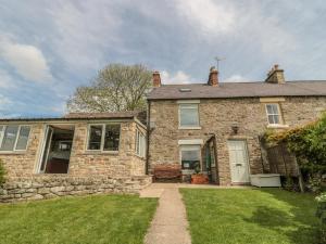 una vecchia casa in pietra con un prato di Hoodgill Barn a Newbiggin