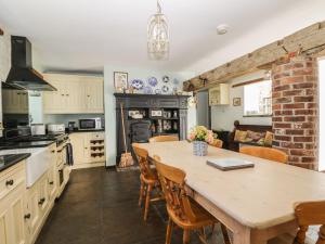uma cozinha com mesa e uma sala de jantar com lareira em Bramhill Barns em Burton Pidsea