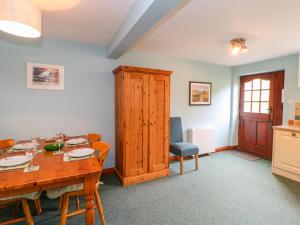 a dining room with a table and a kitchen at Barnbrook in Carperby