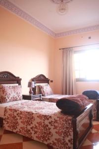 a bedroom with two beds and a window at Résidence dikre in Ouarzazate