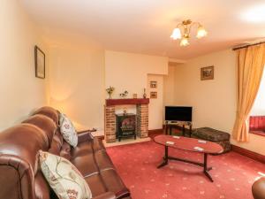 a living room with a couch and a fireplace at Westfield Cottage in Mickleton