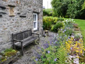 a wooden bench sitting in front of a stone building at Fawber Cottage in Horton in Ribblesdale