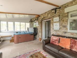 a living room with a couch and a stone wall at Hoodgill Barn in Newbiggin