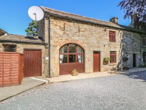 an old stone building with a basketball hoop in front of it at Westfield Cottage in Mickleton