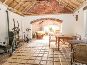 a living room with a table and chairs and a brick wall at Bramhill Barns in Burton Pidsea