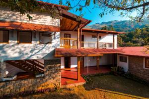 a house with a porch and a balcony at Windermere Estate in Munnar