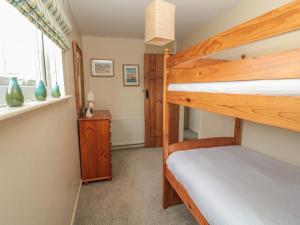 a bedroom with two bunk beds and a window at Shepherds Nook in North Charlton