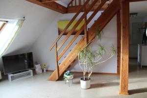 a living room with a staircase and a tv at Ferienwohnung im Galerie-Haus in Urbar