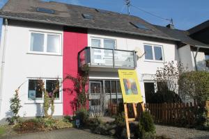 a white and red house with a sign in front of it at Ferienwohnung im Galerie-Haus in Urbar