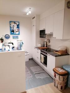 a kitchen with white cabinets and a stove top oven at Tagusnunus in Brussels