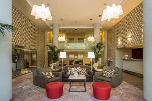 a lobby with couches and chairs and a table at Mamaison Hotel Andrassy Budapest in Budapest