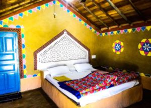 a bedroom with a bed in a room with a blue door at HODKA RANN STAY Resort in Bherandiāla