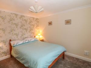 a bedroom with a bed and a ceiling fan at Frodos in Henstridge