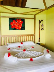 1 dormitorio con 2 camas con flores rojas. en Patatran Village Hotel, en La Digue