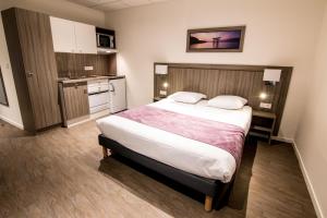 Habitación de hotel con cama y cocina en Tulip Inn Thionville Residences, en Thionville