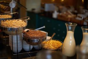 a counter with bowls of food and a bottle of milk at Secrets Lanzarote Resort & Spa - Adults Only (+18) in Puerto Calero