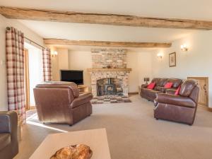 a living room with couches and a fireplace at Glebe Barn in Caynham