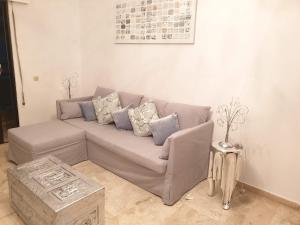 un sofá gris en una sala de estar con mesa en Lemesou Apartments, en Patra