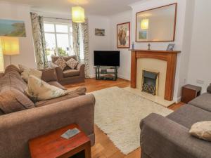 a living room with two couches and a fireplace at 5 Cae Derwydd in Cemaes Bay