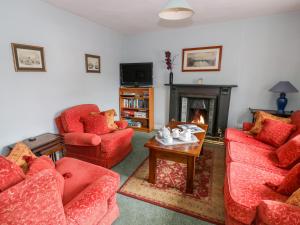 a living room with red chairs and a fireplace at The Lock House in Gloucester
