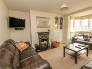 a living room with a couch and a fire place at Gun End Cottage in Rushton Spencer