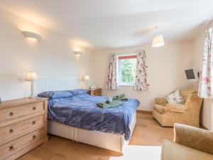 a bedroom with a bed and a chair at The Schoolhouse Brewhouse in Bishops Castle