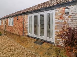 a house with white doors on the side of it at Peardrop Cottage in Saltfleetby Saint Peter