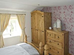 a bedroom with a wooden bed and a dresser at New Cottage Farm in Flash
