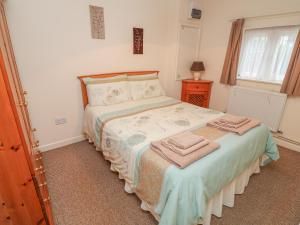 a bedroom with a bed with towels on it at Peardrop Cottage in Saltfleetby Saint Peter