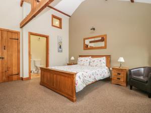 a bedroom with a bed and a chair at Sally's Barn in Grantley