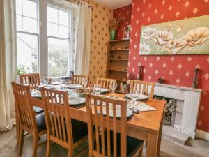 a dining room with a table and chairs and a fireplace at Gorse Bank in Broughton in Furness
