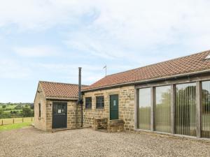 a stone house with a garage and a driveway at Sally's Barn in Grantley