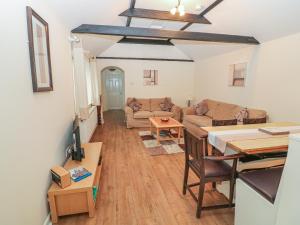 a living room with a couch and a table at Peardrop Cottage in Saltfleetby Saint Peter
