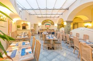 a restaurant with tables and chairs in a room at Hotel Nettuno in Ischia