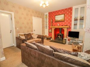 a living room with a couch and a fireplace at Gorse Bank in Broughton in Furness