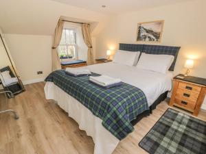 a bedroom with a bed with two towels on it at Alma Cottage in Tyndrum