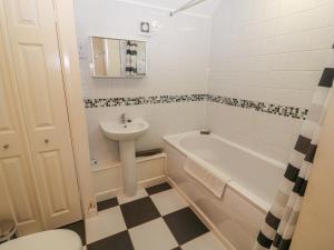a bathroom with a sink and a tub and a toilet at Peardrop Cottage in Saltfleetby Saint Peter +11 photos